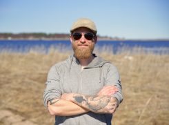 Kuvassa Janne Tarvainen taustallaan meri ja merenranta.